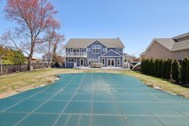 Rear view of house featuring a patio area, a balcony, a fenced backyard, and a lawn | Image 45