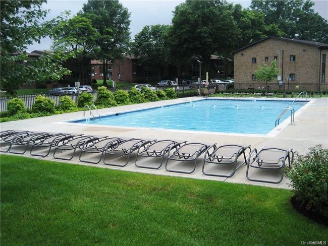 Community pool with a patio area, fence, and a yard | Image 16