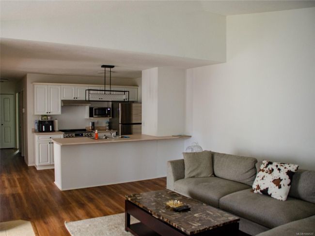 Kitchen featuring a baseboard radiator, a sink, a tiled fireplace, and light countertops | Image 16