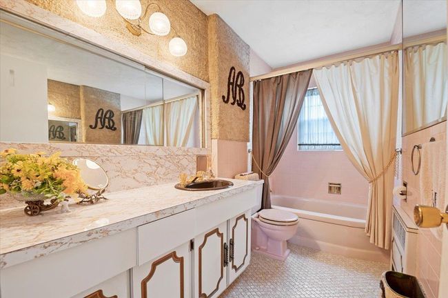 Bathroom featuring shower / bath combination with curtain, vanity, tile patterned flooring, tile walls, and decorative backsplash | Image 19