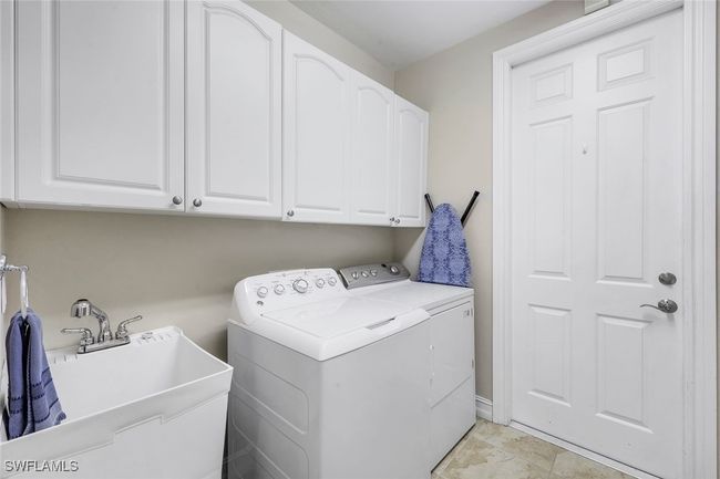 Washroom featuring cabinets, washer and clothes dryer, and sink | Image 18