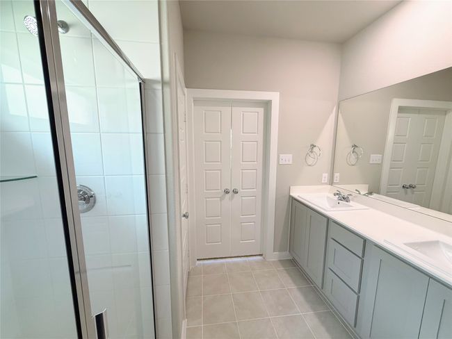 Bathroom featuring tile patterned floors, a stall shower, and double vanity | Image 32