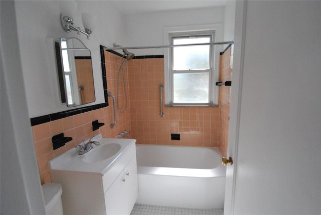 Full bath featuring window, tile walls, toilet, vanity, and bathing tub / shower combination | Image 11