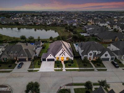 Amazing aerial shot of this gorgeous Perry home situated on a lake lot on a quiet street in the sought after community of Cane Island zoned to Katy ISD. Lush landscaping, well manicured front lawn and a wonderful back patio perfect to set up, an outdoor sitting area and a beautiful view of the lake with no back neighbors. | Image 2