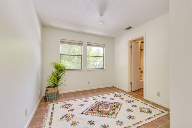 Tiled empty room featuring a textured ceiling and baseboards | Image 16