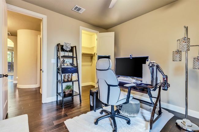 Bedroom used as office featuring dark wood-type flooring, ceiling fan, arched walkways | Image 11