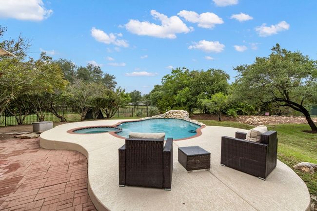 View of pool featuring a patio area, a fenced backyard, and a pool with connected hot tub | Image 36