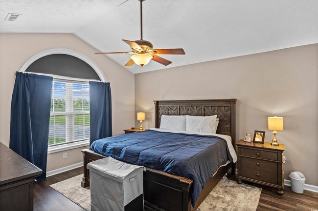Bedroom featuring dark wood finished floors, lofted ceiling, and a ceiling fan | Image 10