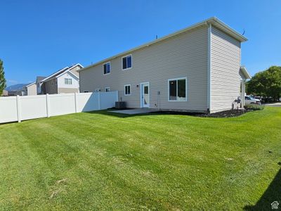 Back of house featuring cooling unit, a patio, and a yard | Image 2