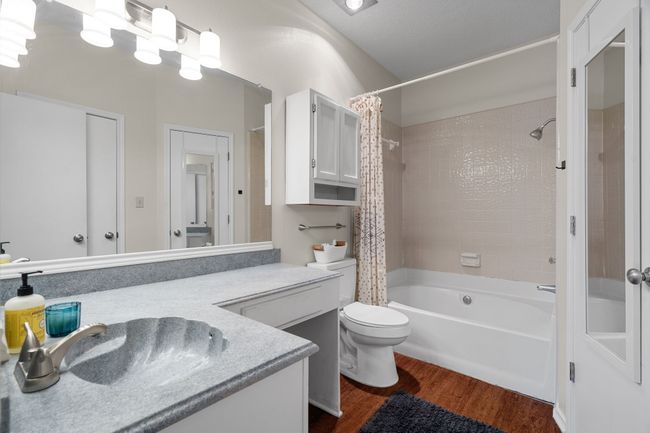 Full bath featuring shower / bath combination with curtain, vanity, and wood finished floors | Image 15