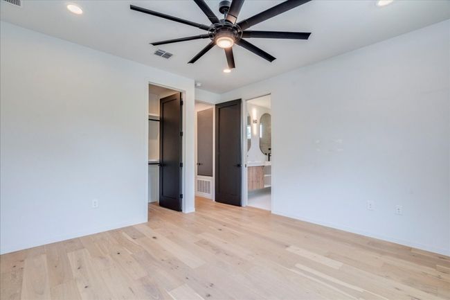 Unfurnished bedroom with light wood-type flooring, recessed lighting, a spacious closet, connected bathroom, and a ceiling fan | Image 14