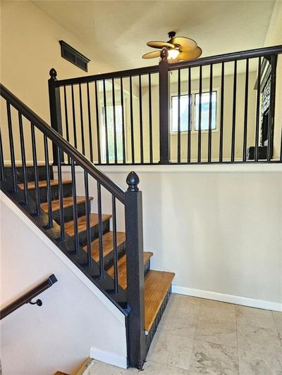 Staircase featuring ceiling fan | Image 2