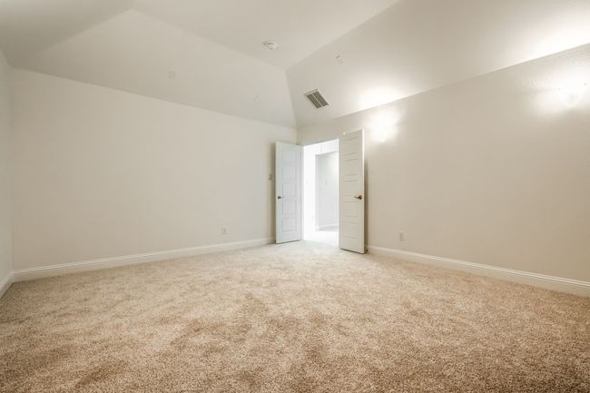Empty room featuring high vaulted ceiling, visible vents, baseboards, and light carpet | Image 26
