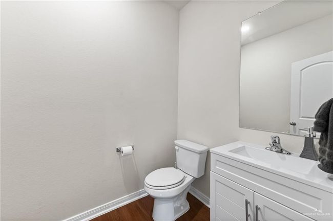 Half bathroom with wood finished floors, baseboards, toilet, and vanity | Image 32