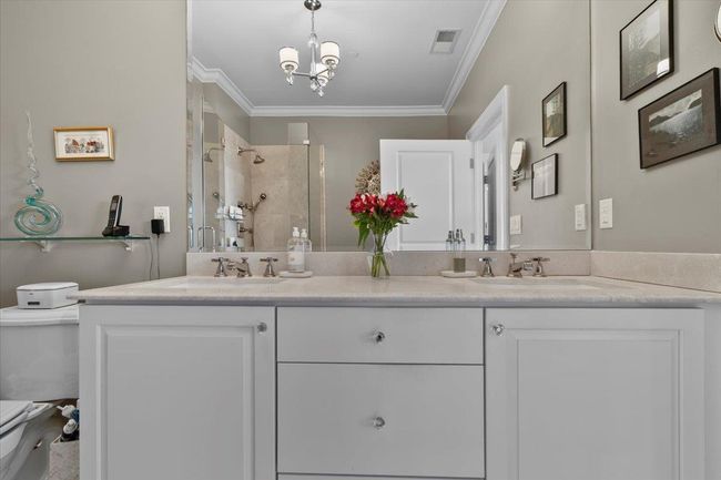 Full bathroom with visible vents, a shower stall, a sink, toilet, and ornamental molding | Image 14