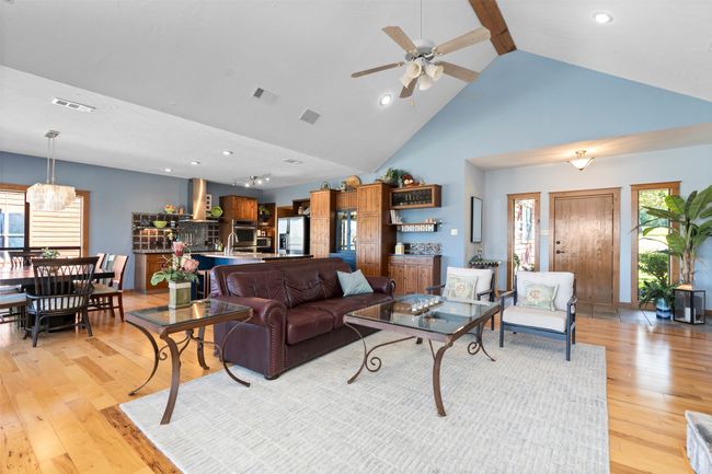 Living room featuring light wood-type flooring, ceiling fan, sink, and high vaulted ceiling | Image 5