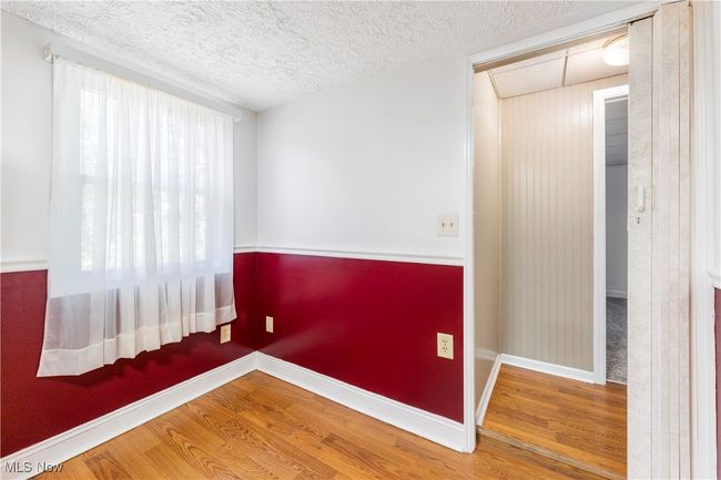 Unfurnished room with a textured ceiling, wood finished floors, and baseboards | Image 14