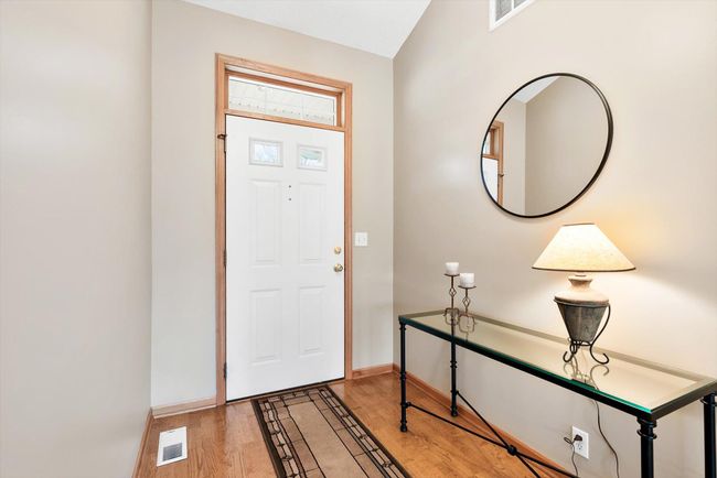 Charming architectural detail with a transom window above the front door adds natural light and character. | Image 6