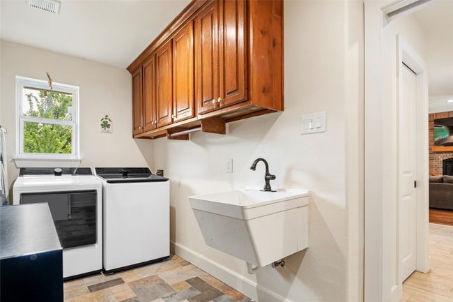 Spacious laundry room with a utility sink, water line for a fridge, space for deep freezer, along with cabinet space | Image 9