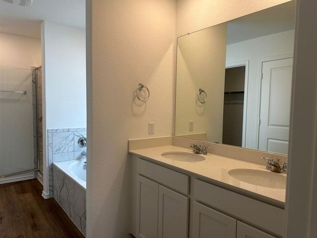 Bathroom featuring wood finished floors, a shower stall, double vanity, and a bath | Image 32