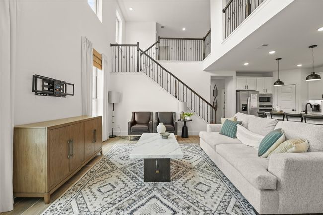 Living area with a towering ceiling, stairway, light wood-style floors, plenty of natural light, and recessed lighting | Image 17