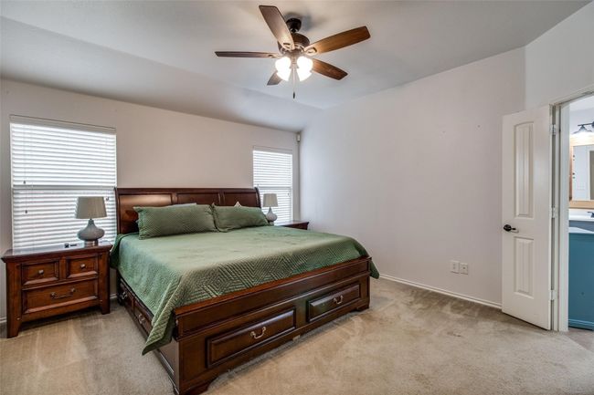 Bedroom featuring light colored carpet, a ceiling fan, and baseboards | Image 16