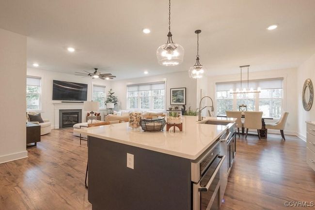 Kitchen featuring a chandelier, dark wood finished floors, plenty of natural light, a center island with sink, and recessed lighting | Image 28