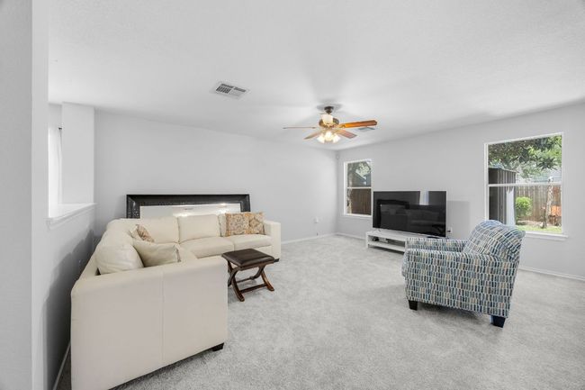 Newly carpeted living room features ceiling fan and dual pane low-e windows. | Image 6