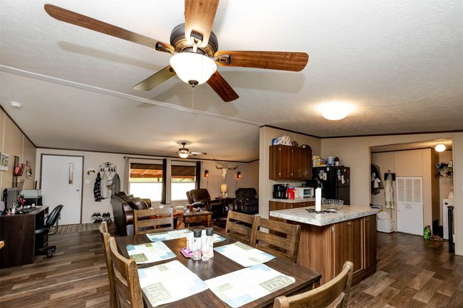Dining area with dark wood-style flooring, ceiling fan, and a textured ceiling | Image 15