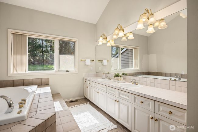 Primary bathroom features double sinks, tons of counter space, a jetted tub and a large linen closet (along back wall). | Image 30