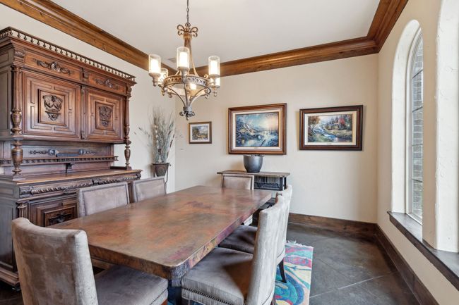 Dining area featuring baseboards, crown molding, and a chandelier | Image 17