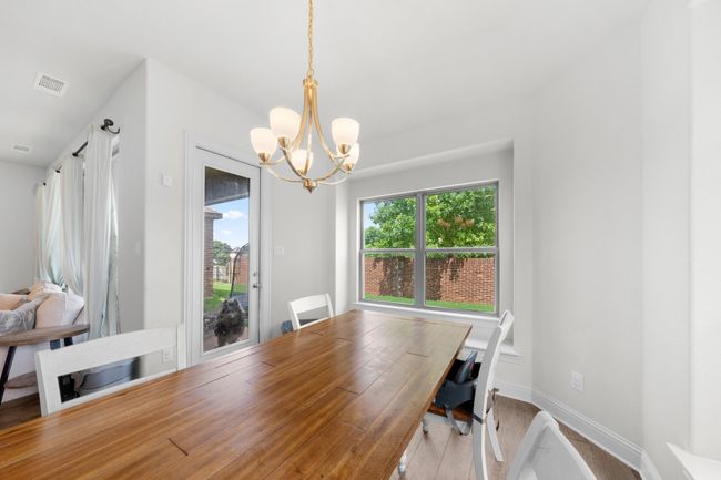 Dining room with a chandelier and wood finished floors | Image 7