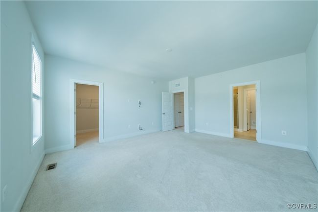 Unfurnished bedroom featuring a walk in closet, light colored carpet, and baseboards | Image 34