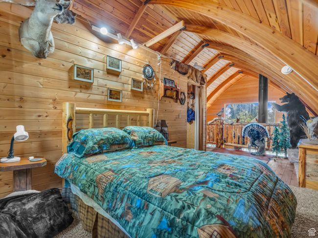Bedroom featuring wood ceiling, wooden walls, and hardwood / wood-style flooring | Image 20