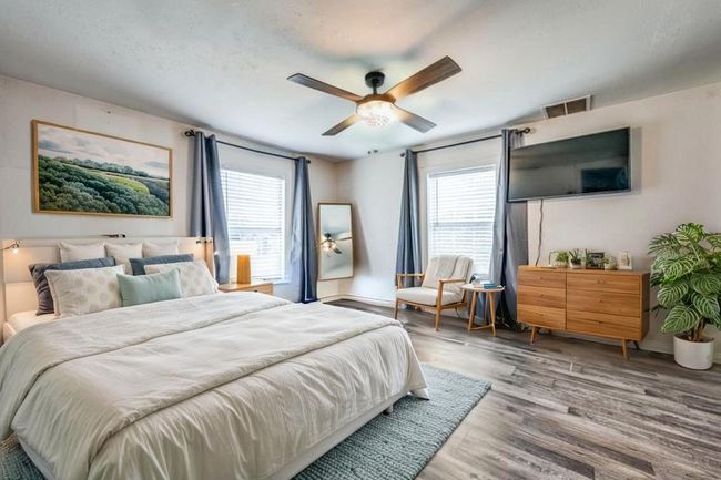 Bedroom with multiple windows, wood finished floors, and ceiling fan | Image 5