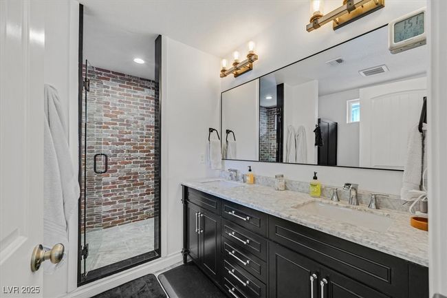 Bathroom with a shower stall, visible vents, and a sink | Image 17