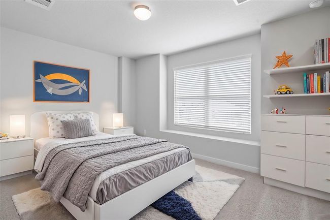 This secondary bedroom features custom paint, plush carpet, and large windows with blinds! | Image 11