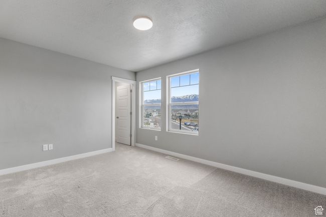 Empty room featuring visible vents, baseboards, a textured ceiling, and light colored carpet | Image 28
