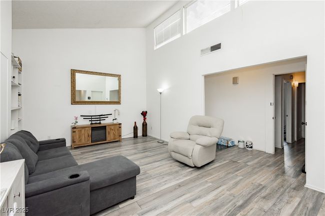 Living room with a towering ceiling and light wood-type flooring | Image 5