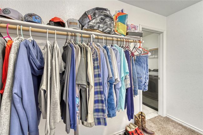 Spacious closet with washer / clothes dryer and light carpet | Image 23