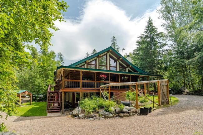 View of front facade featuring stairway, a wooden deck, dirt driveway, and a chimney | Image 11