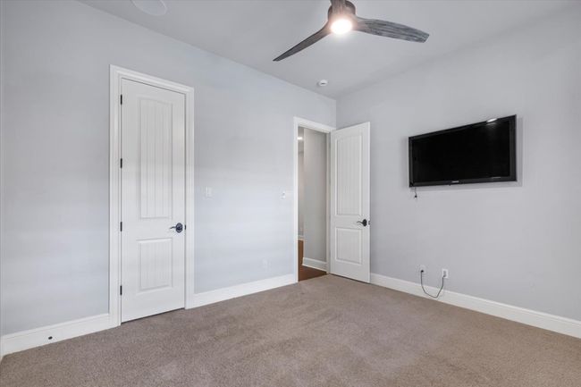 Unfurnished bedroom featuring a ceiling fan, baseboards, and carpet | Image 21