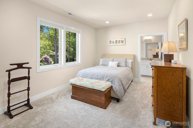 Secondary en-suite bedroom on the upper floor - this room looks out over the front entry to the forest beyond. | Image 19