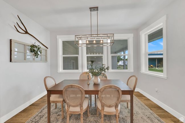 Dining space featuring a chandelier and wood finished floors | Image 15