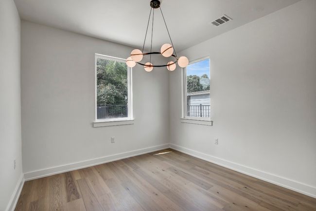Empty room featuring a chandelier, wood finished floors, and baseboards | Image 12