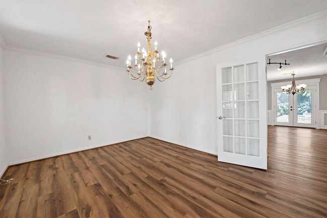 Wood floors and crown molding add an upscale air to this dining room. Dining room opens to kitchen for serving ease while entertaining. | Image 8
