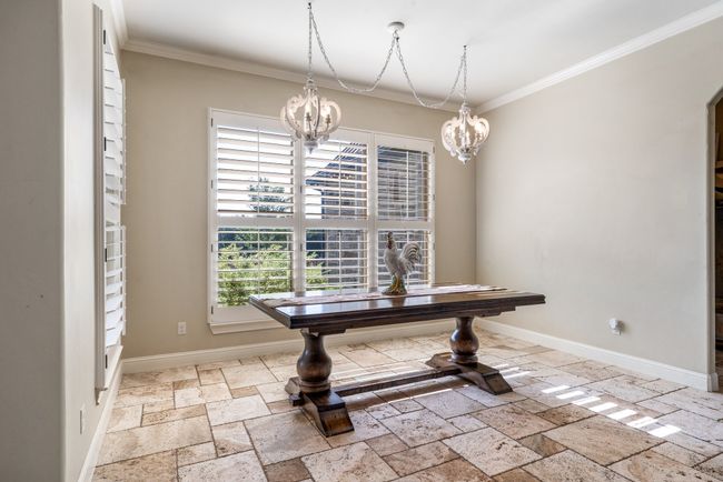 Dining space with a chandelier, stone tile floors, and crown molding | Image 17