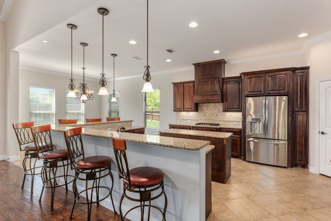 Kitchen featuring a breakfast bar area, tasteful backsplash, appliances with stainless steel finishes, and a spacious island | Image 20