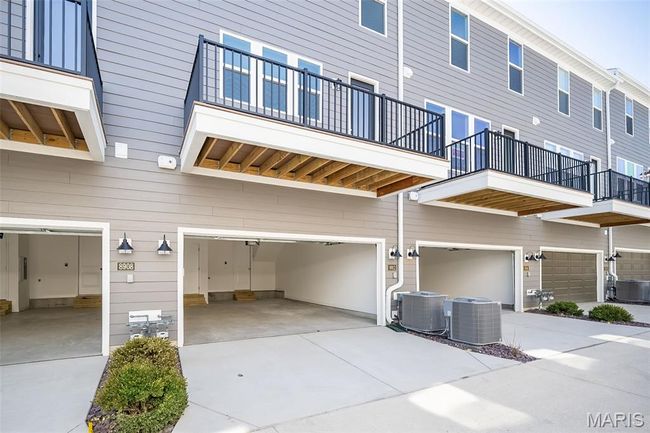 Back of house with an attached garage, a balcony, and driveway | Image 38