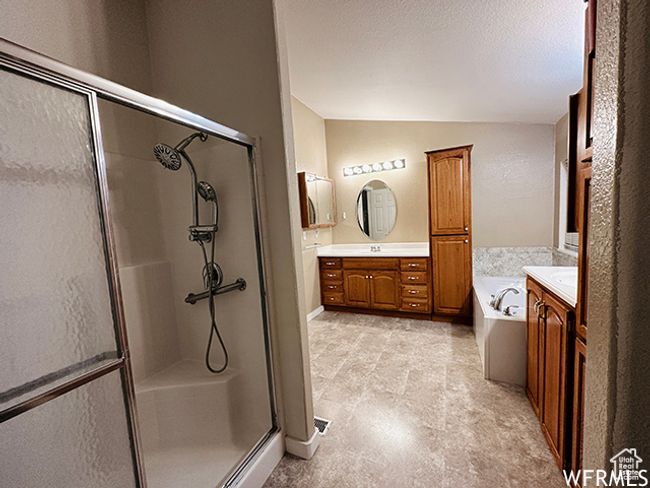 Full bath with vaulted ceiling, vanity, a garden tub, a shower stall, and a textured ceiling | Image 8